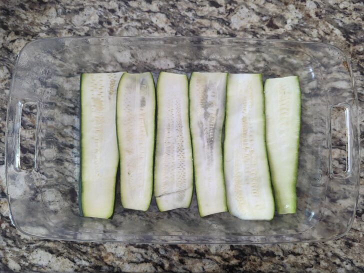 A layer of zucchini strips in a baking dish.