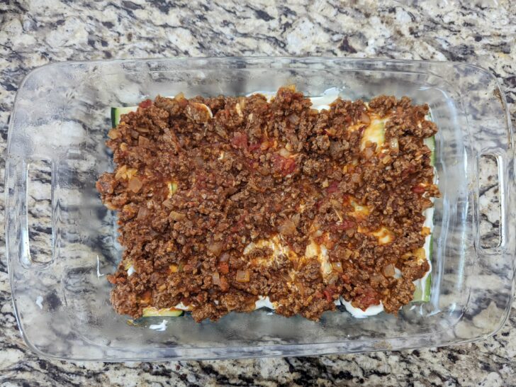 Top the zucchini and cream cheese layers with the beef mixture.