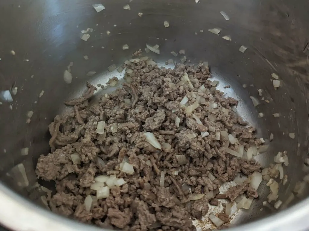 Onion and garlic cooking with ground beef.