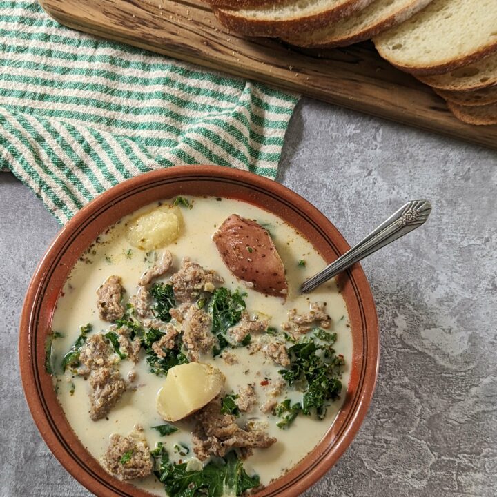Zuppa Toscana Instant Pot in a bowl with bread in the background.