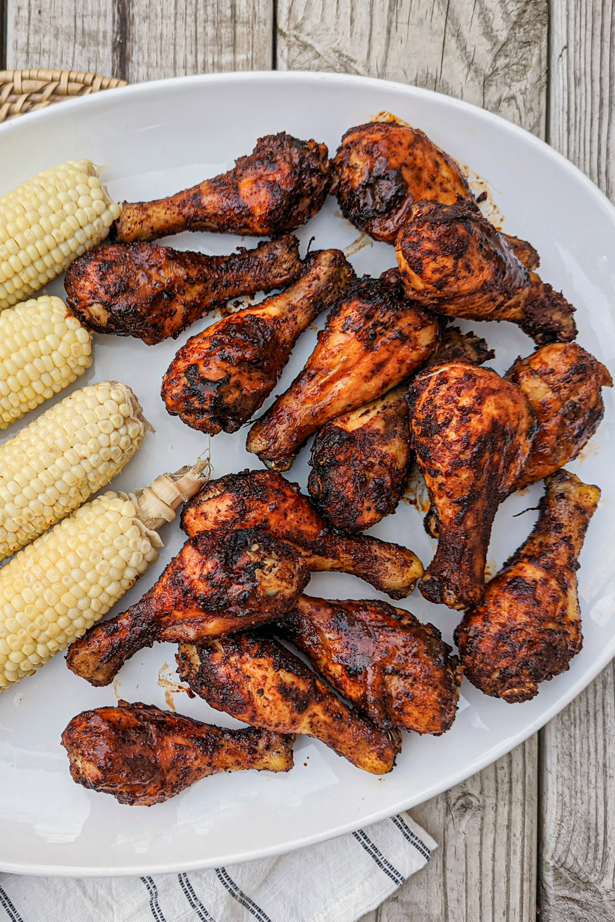 BBQ Baked Chicken Legs on a platter with corn.