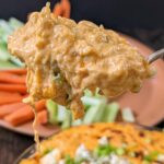 A spoon scooping into Instant Pot Buffalo Chicken Dip.