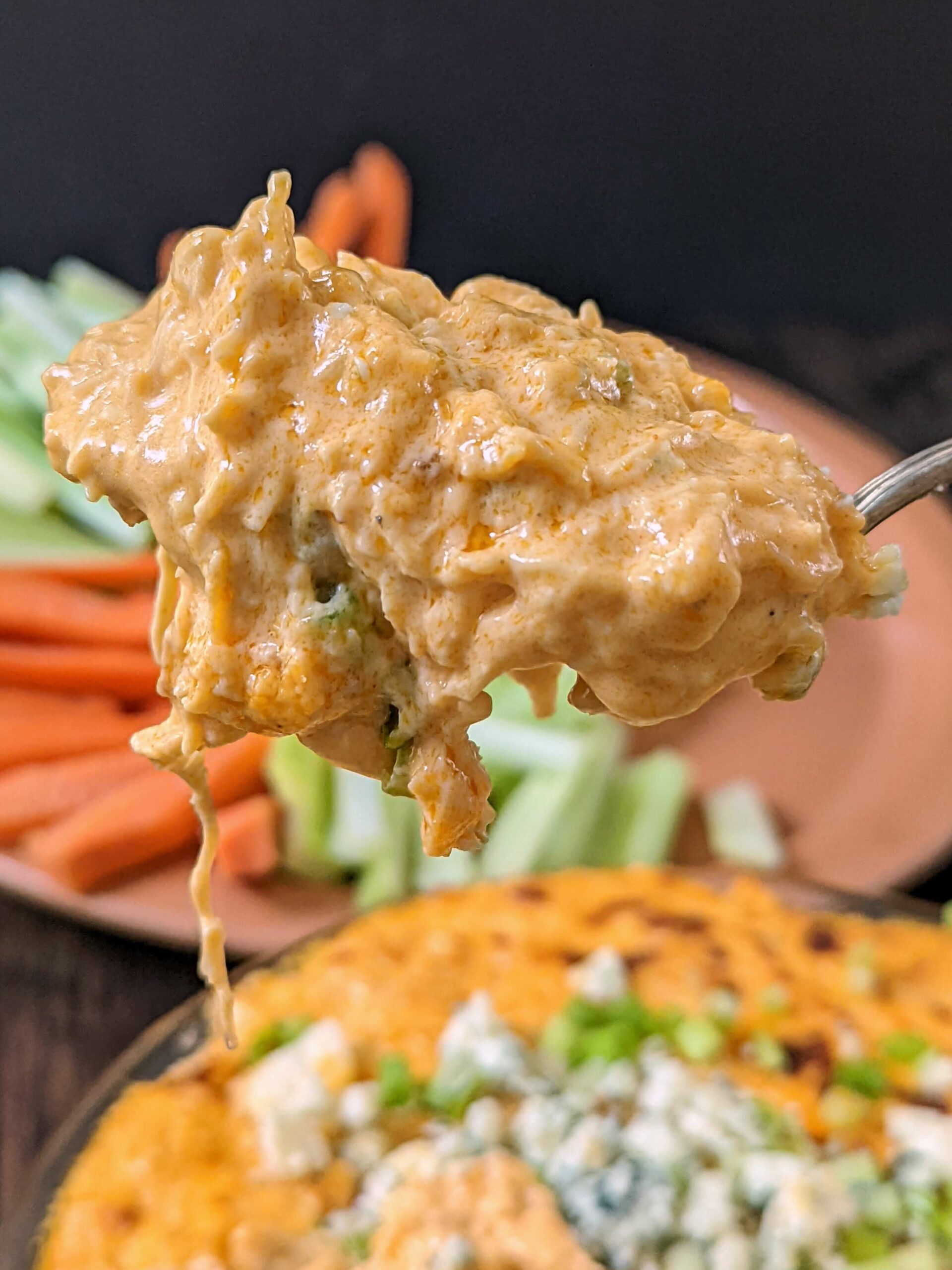 A spoon scooping into Instant Pot Buffalo Chicken Dip.