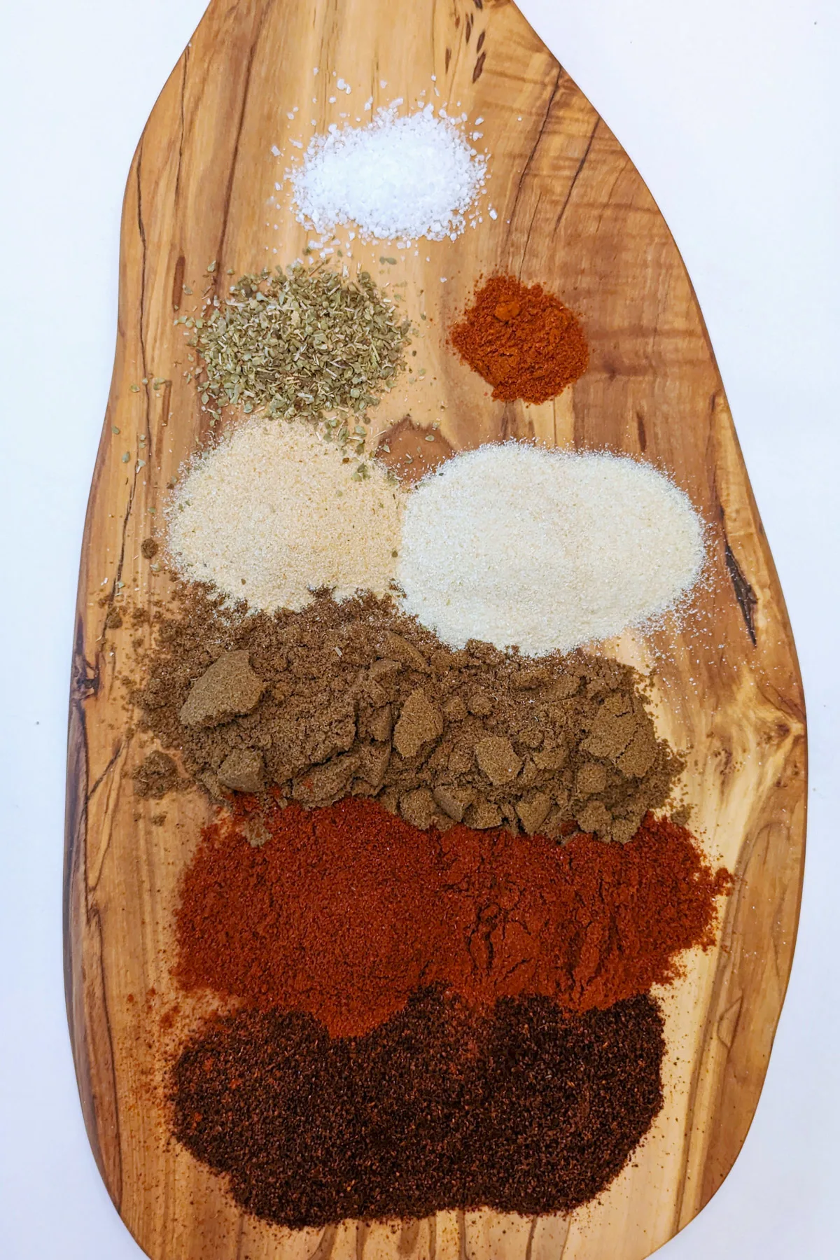 Each of the spices on a wooden board.