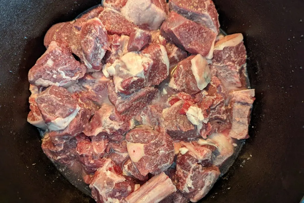 Cook the goat or mutton until tender to create the base for bhuna gosht.