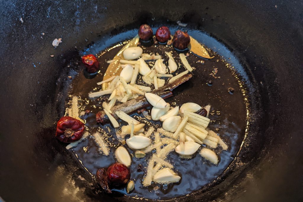 Whole spices, garlic, and ginger in a dutch oven. 