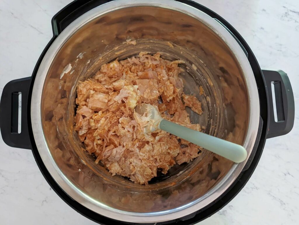 Add all of the ingredients apart from the cheddar cheese to the Instant Pot for buffalo chicken dip.
