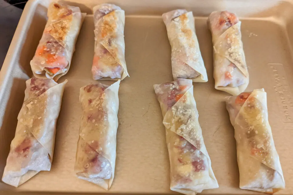 Corned Beef and Cabbage Egg Rolls on a rimmed baking sheet.