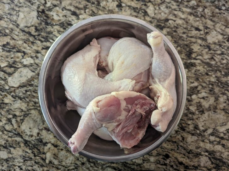 Raw chicken in a mixing bowl.