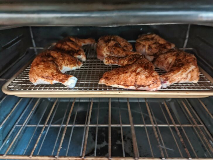 Roasted jerk chicken roasting in the oven.