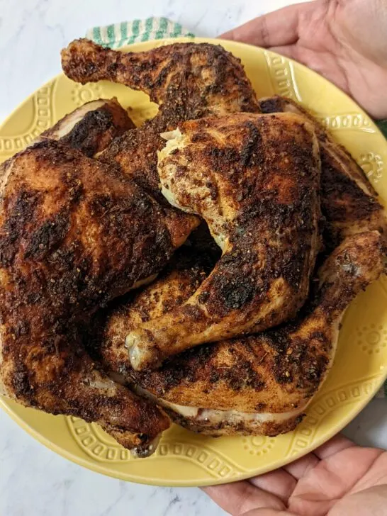 Roasted jerk chicken on a serving plate.