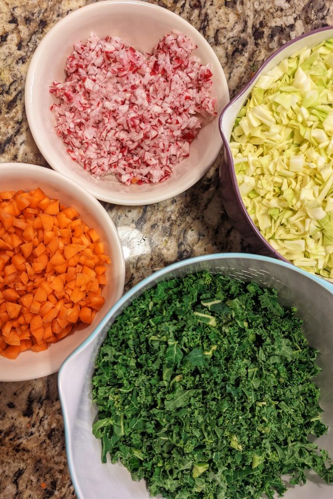 Chop all the ingredients for the chopped salad recipe finely before tossing them together in a mixing bowl.