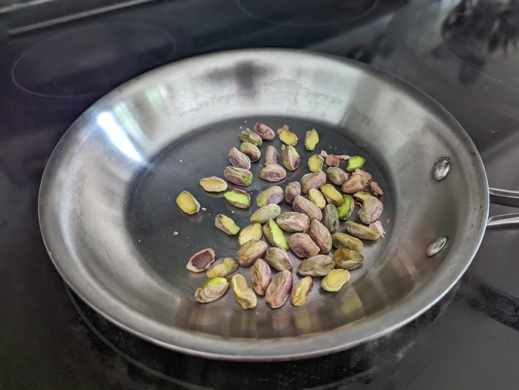Pistachios toasting in a pan. 