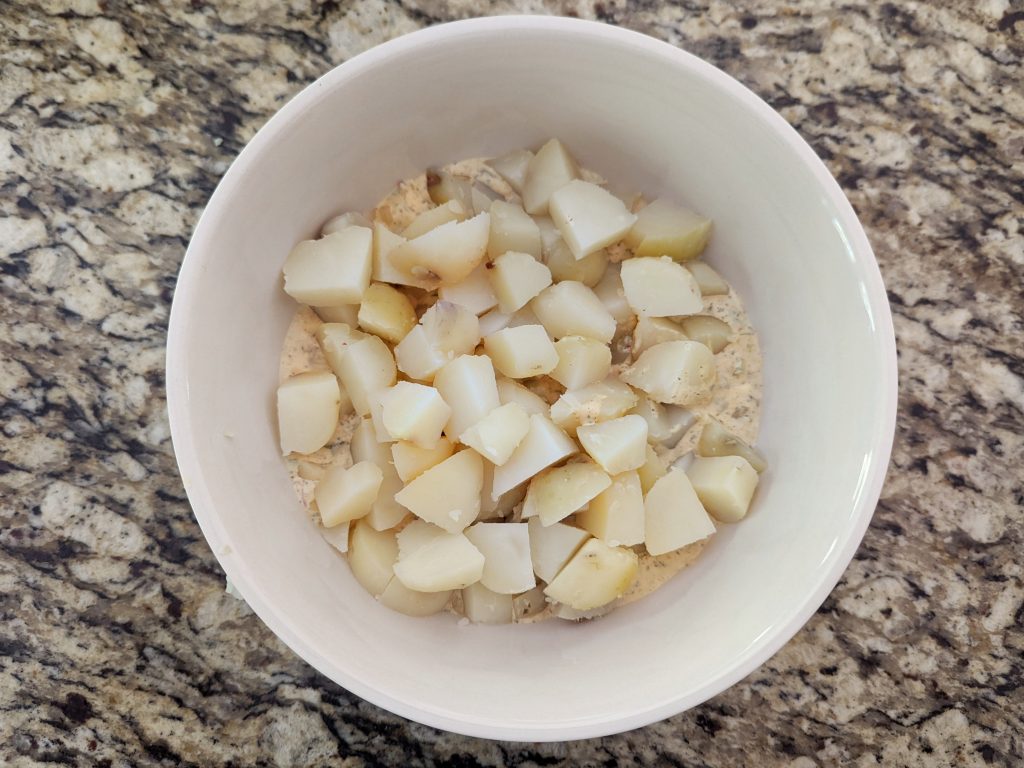 Add the cubed the potatoes to the dressing. 
