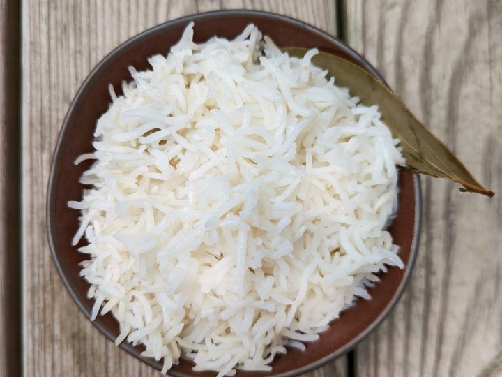 A bowl of basmati rice with a bay leaf for garnish.