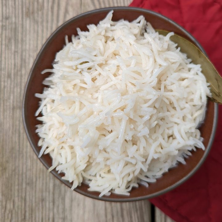 A bowl of basmati rice with a bay leaf for garnish.