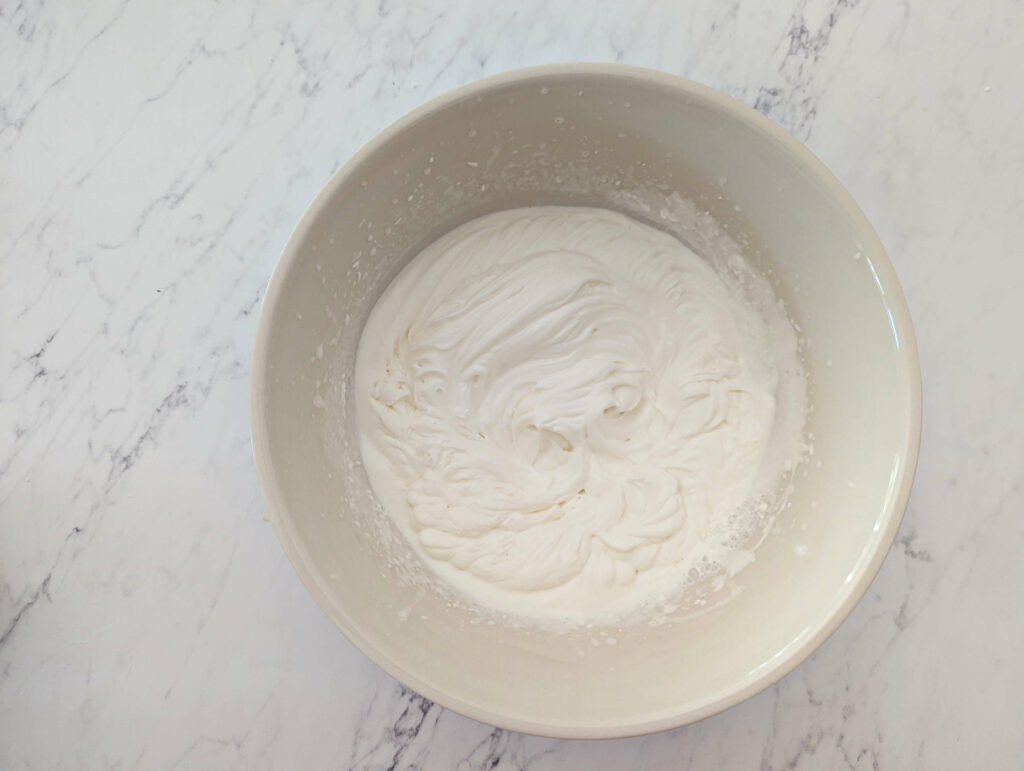 Whipped cream whipped until thick with peaks.