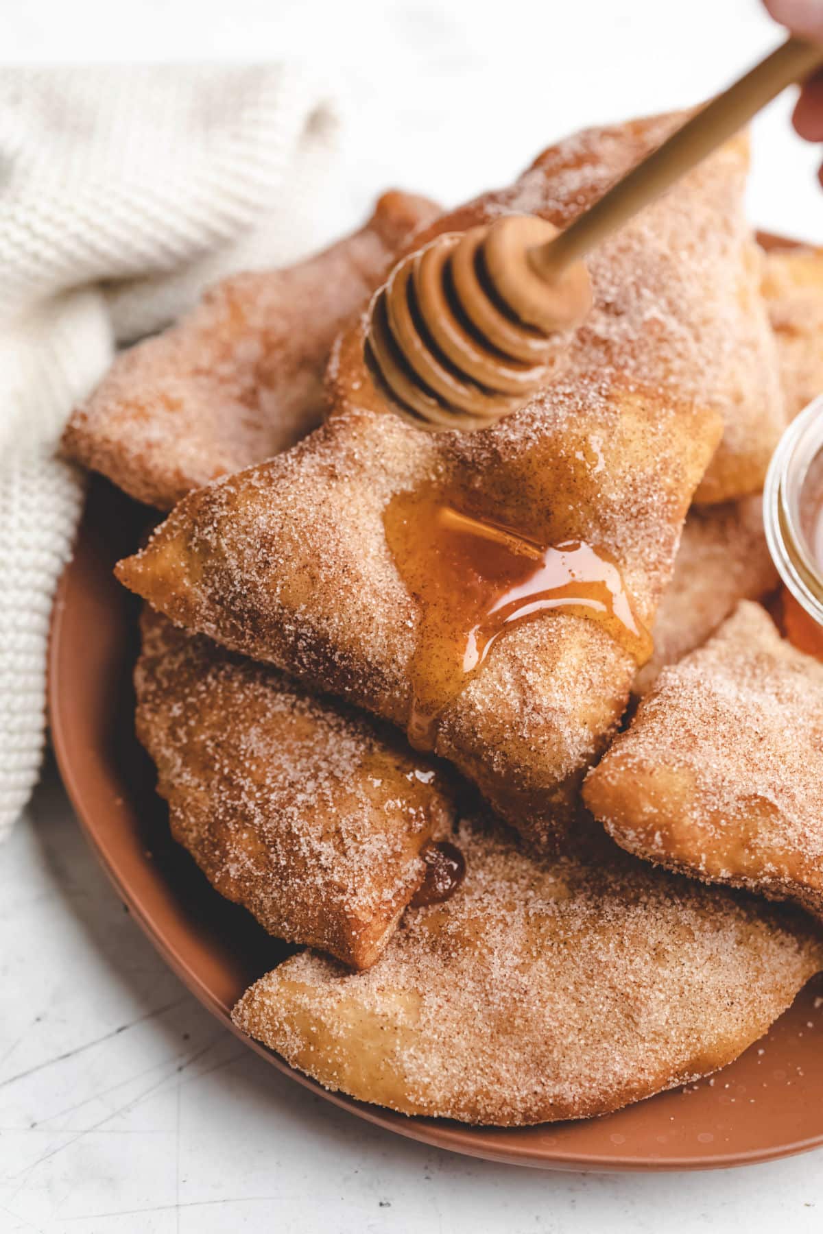 Sopaipillas on a plate with honey.
