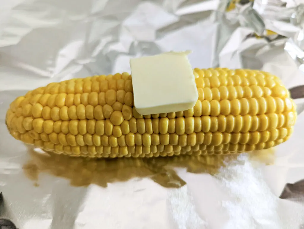 Butter on an ear of corn in foil.