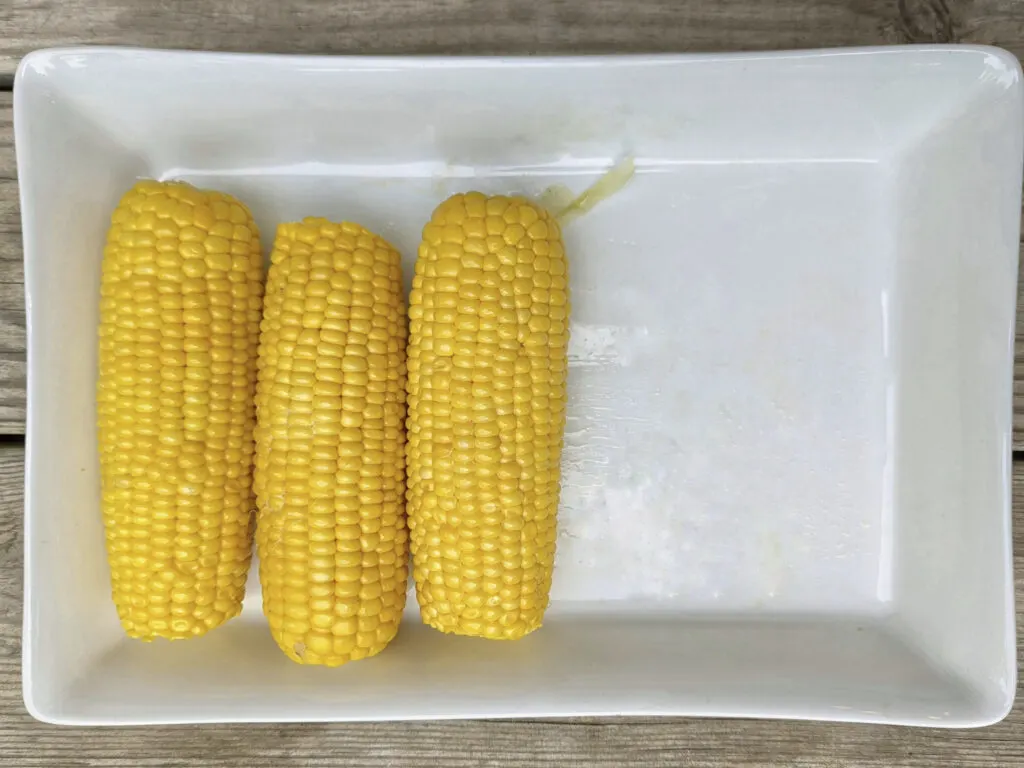 Boiled corn on the cob on a serving tray.
