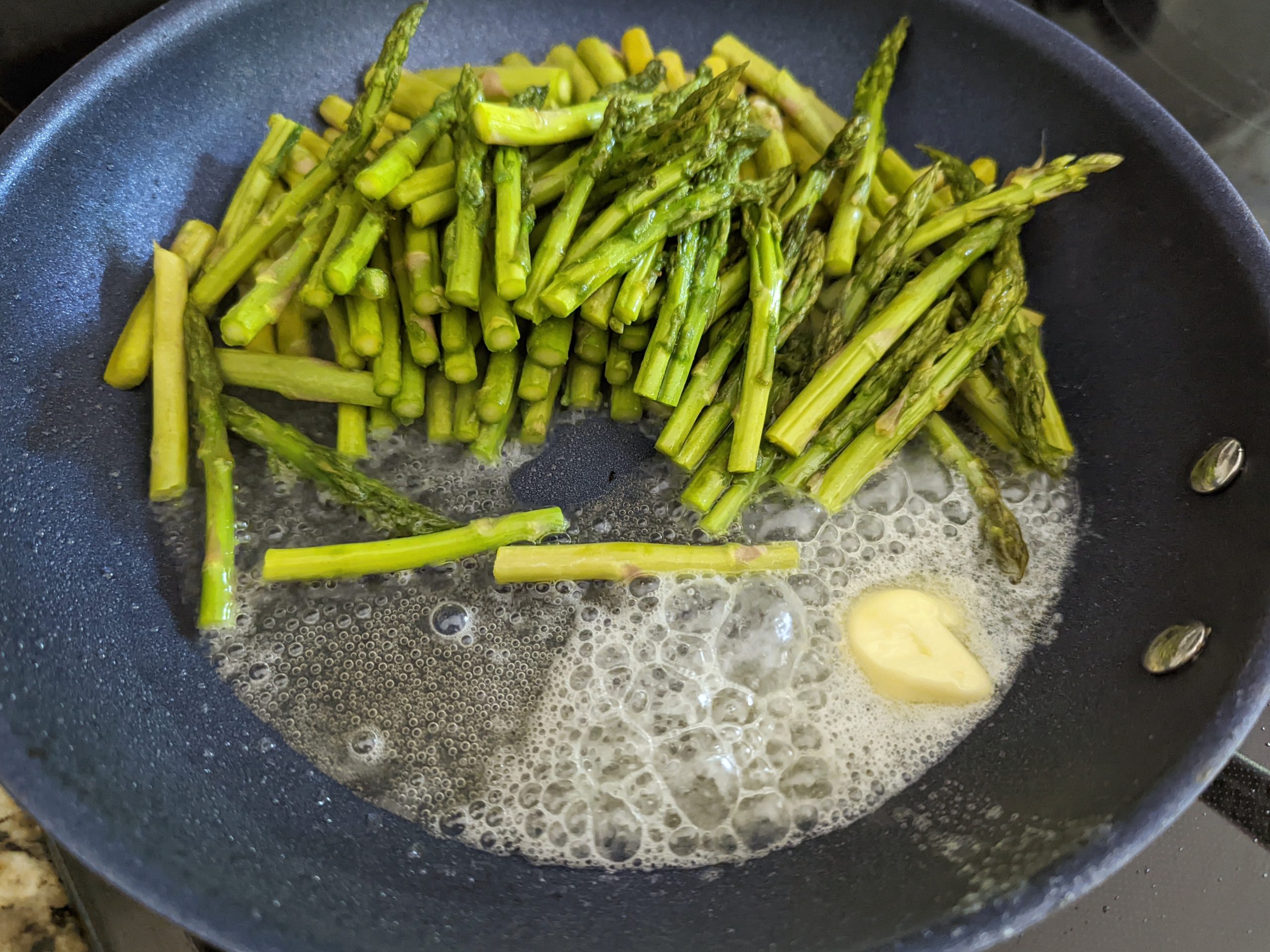 Add butter and asparagus to the pan with oil and saute.