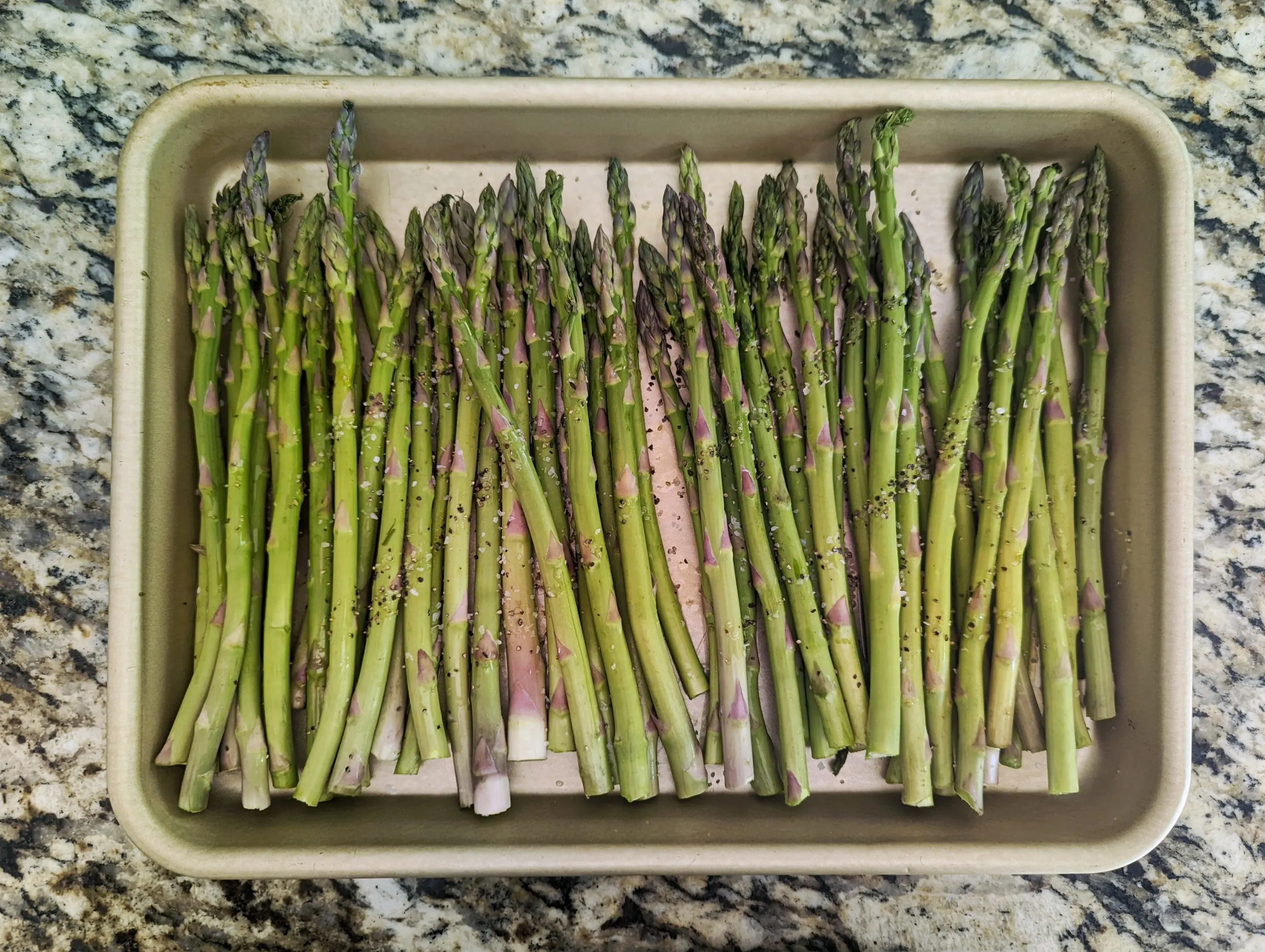 Line the asparagus onto the baking sheet and drizzle with oil and season.