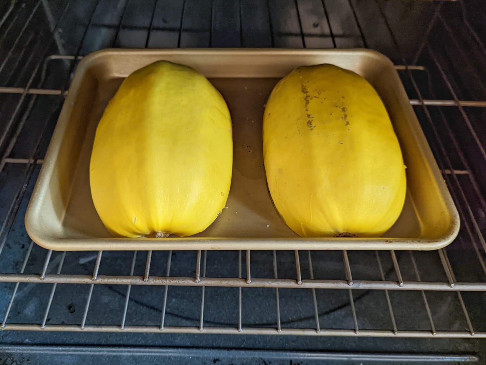 Two halves of the spaghetti squash baking in the oven.
