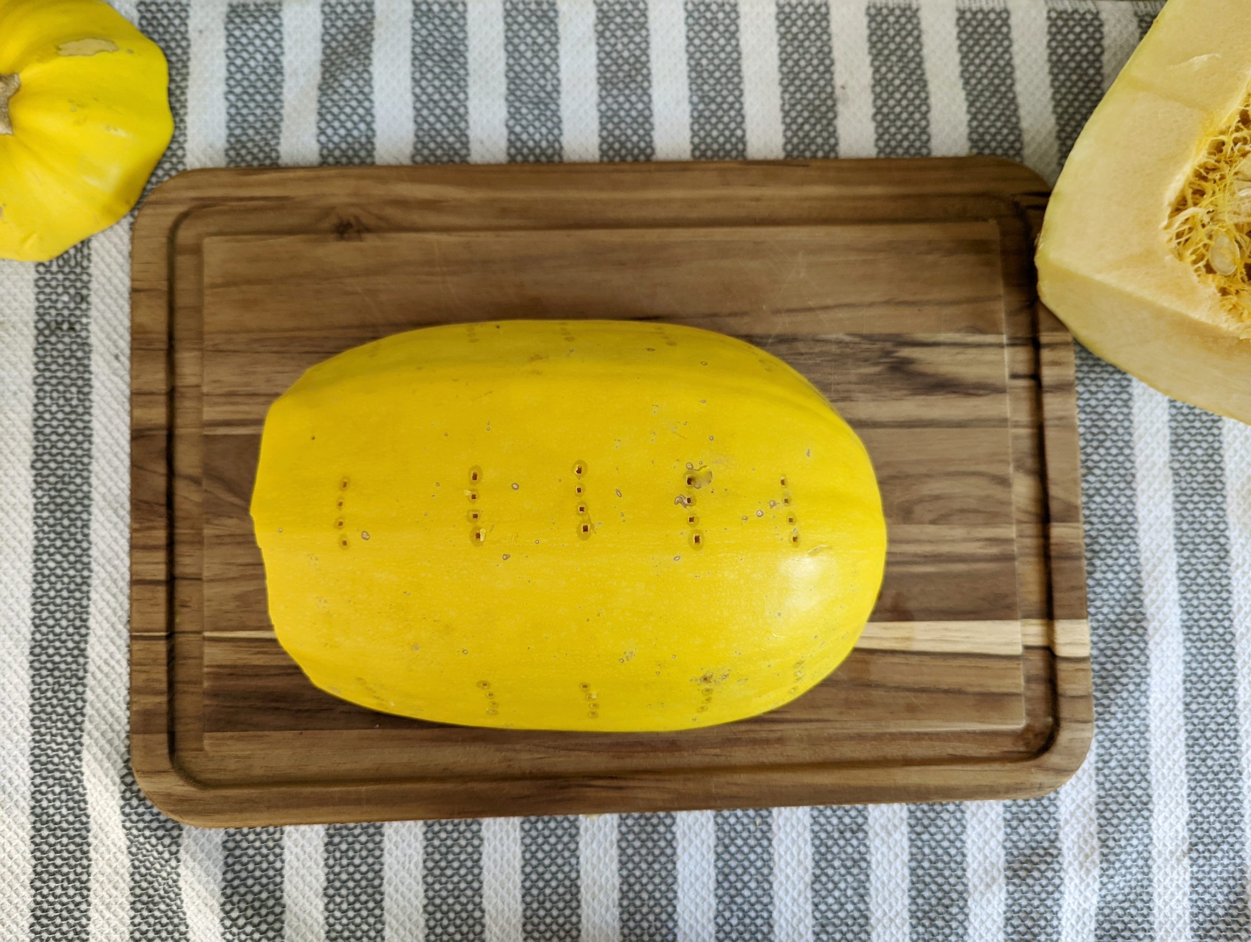 A spaghetti squash half set into a glass dish and poked with a fork.