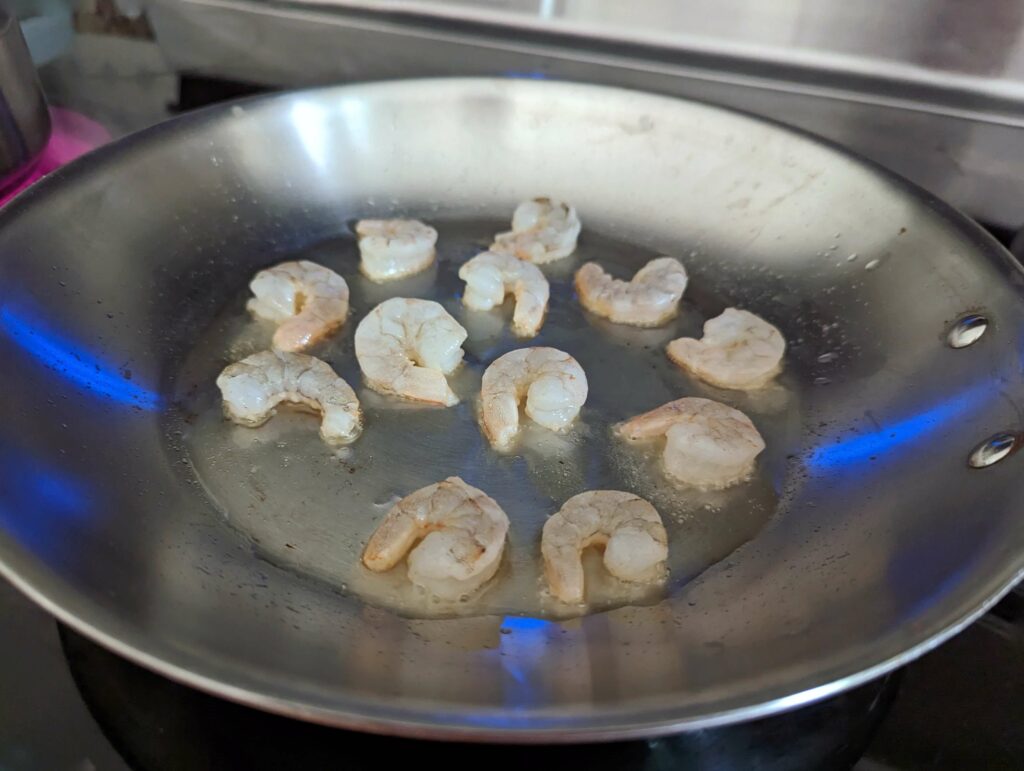 Searing the shrimp in a pan.