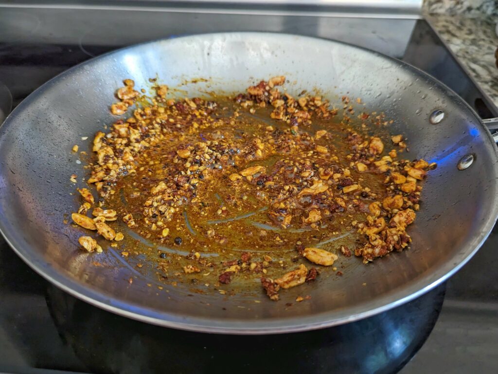 Avocado oil, peanuts and spices in a pan.