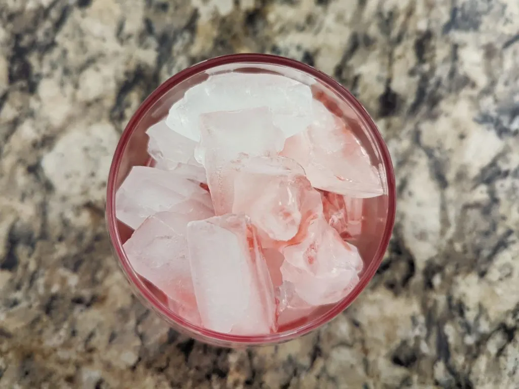 A glass filled with ice, ginger ale, and grenadine.