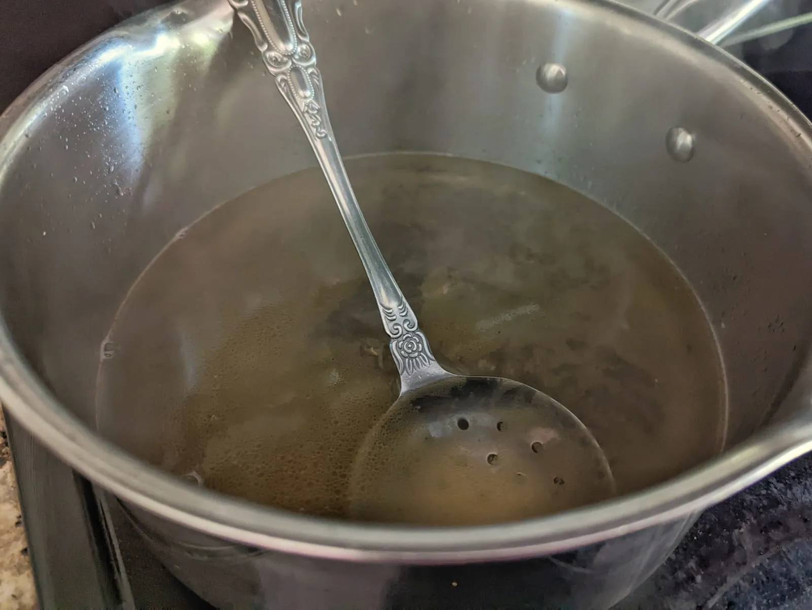 Shrimp stock boiling in a sauce pan.