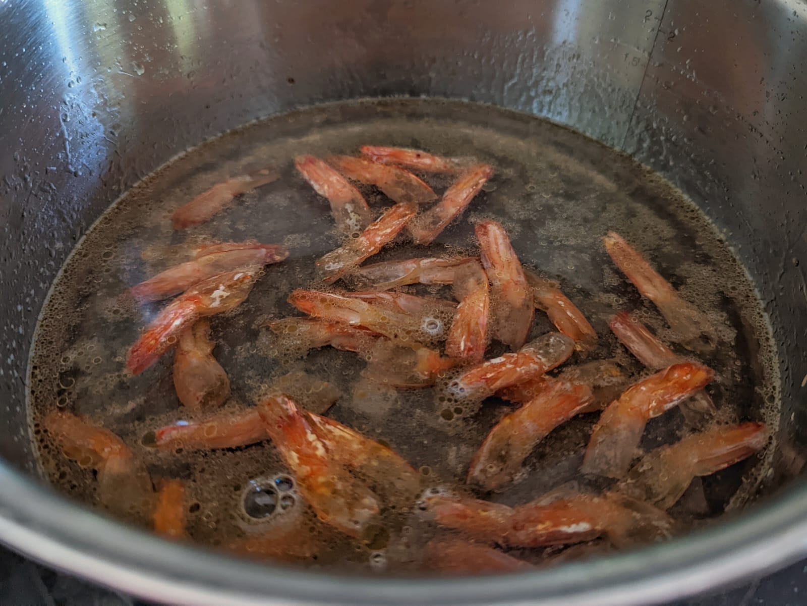 Shrimp tails boiling in water with salt.