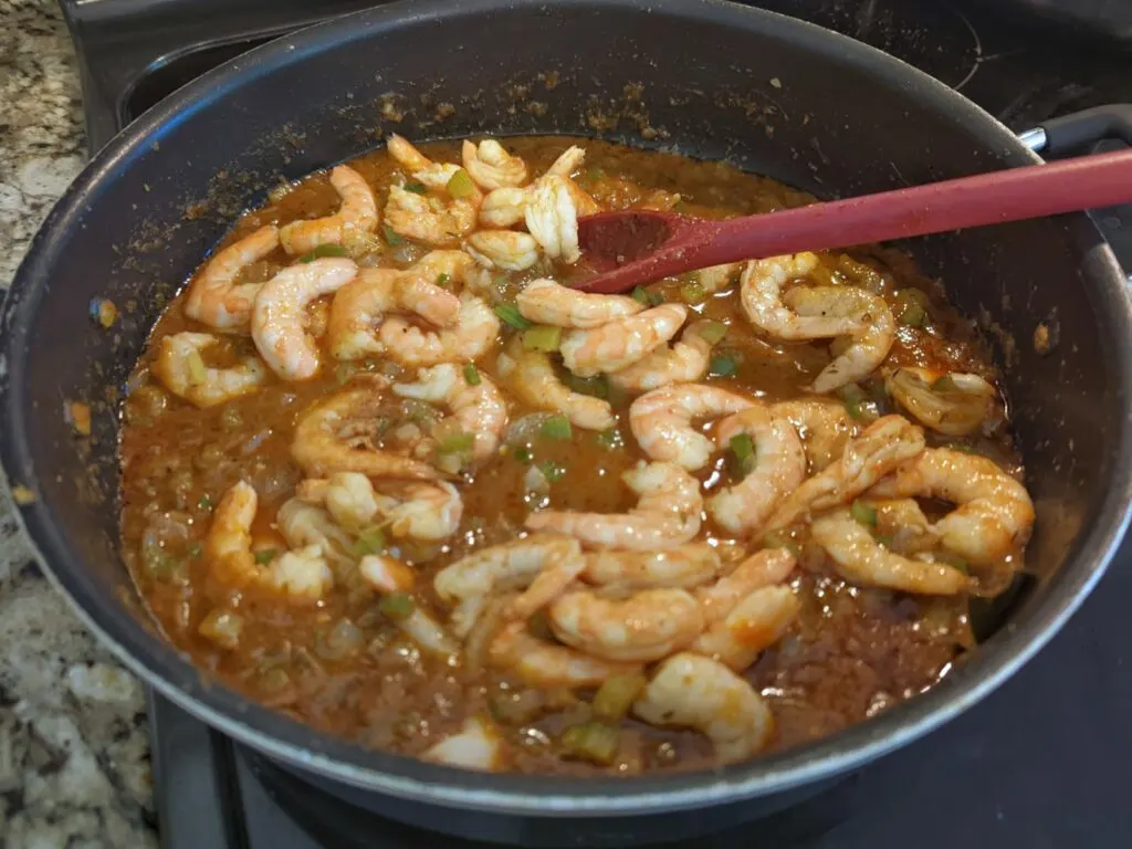 Shrimp added to the étouffée sauce in a pan.