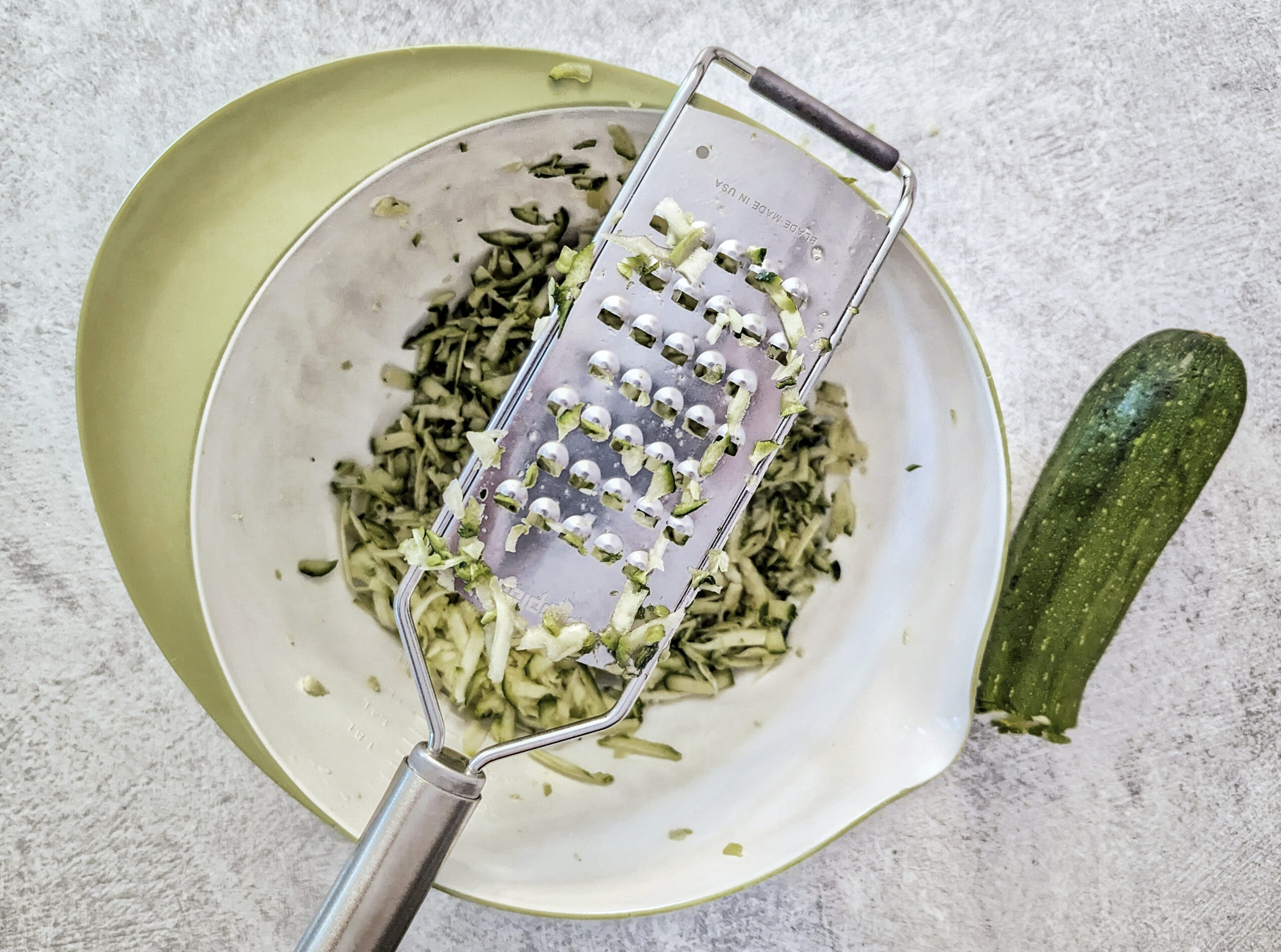 Grate the zucchini into a mixing bowl.
