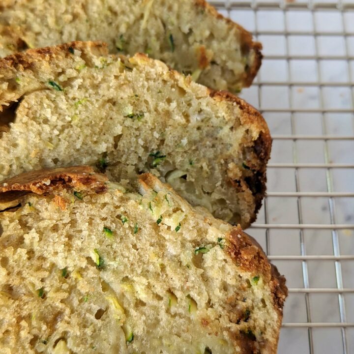 Sliced zucchini bread on a cooling rack.
