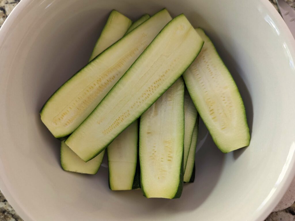 Strips of zucchini in a mixing bowl.
