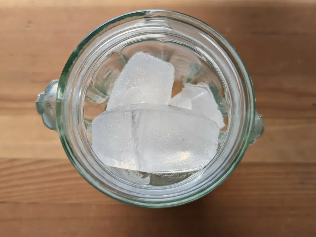 Fill a glass with ice.