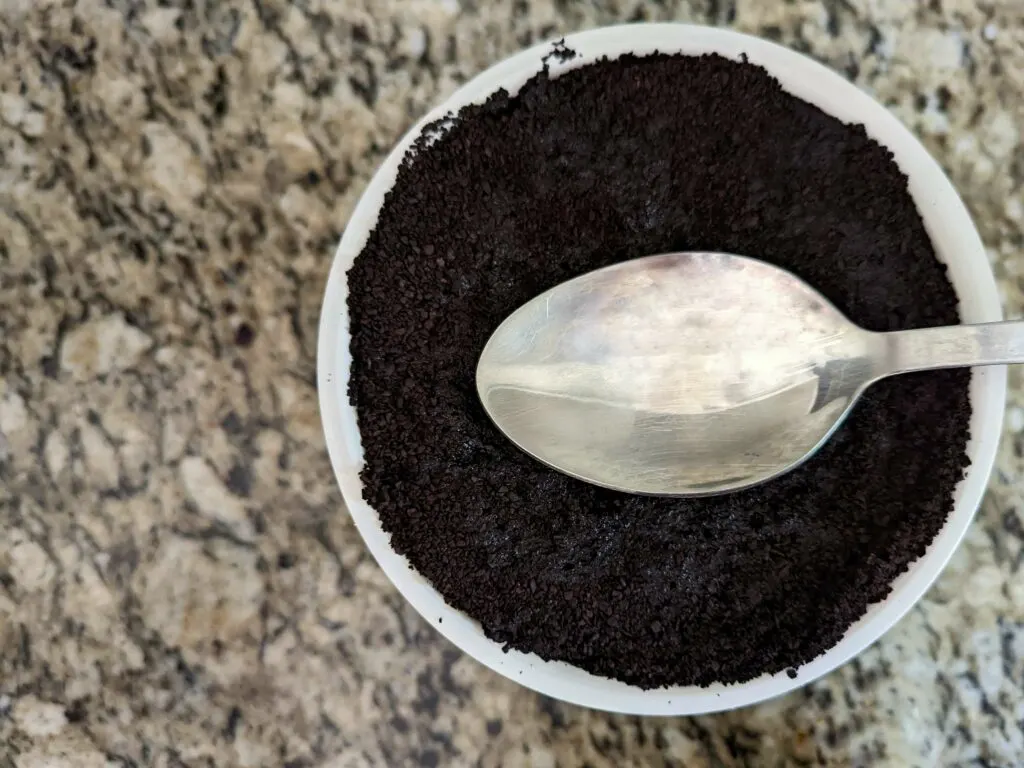 Press the coffee down lightly into the water using the backside of a spoon.