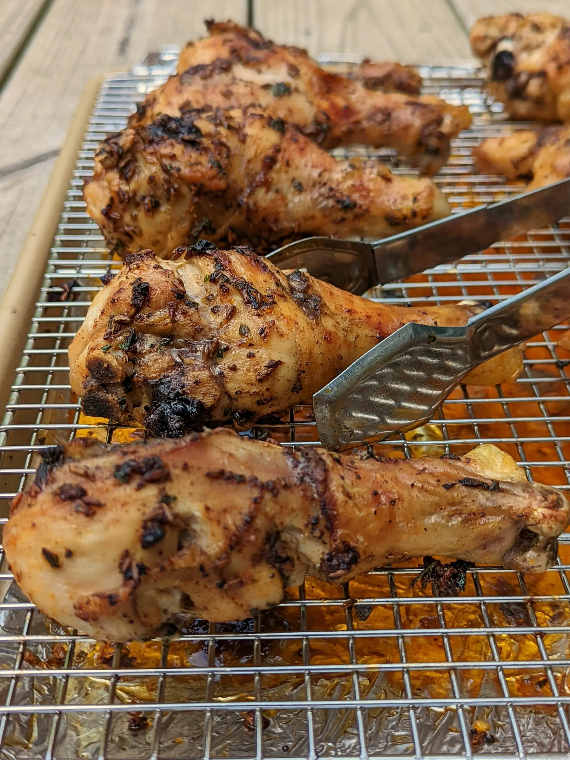 Roasted chicken drumsticks lined onto a rimmed baking sheet. 
