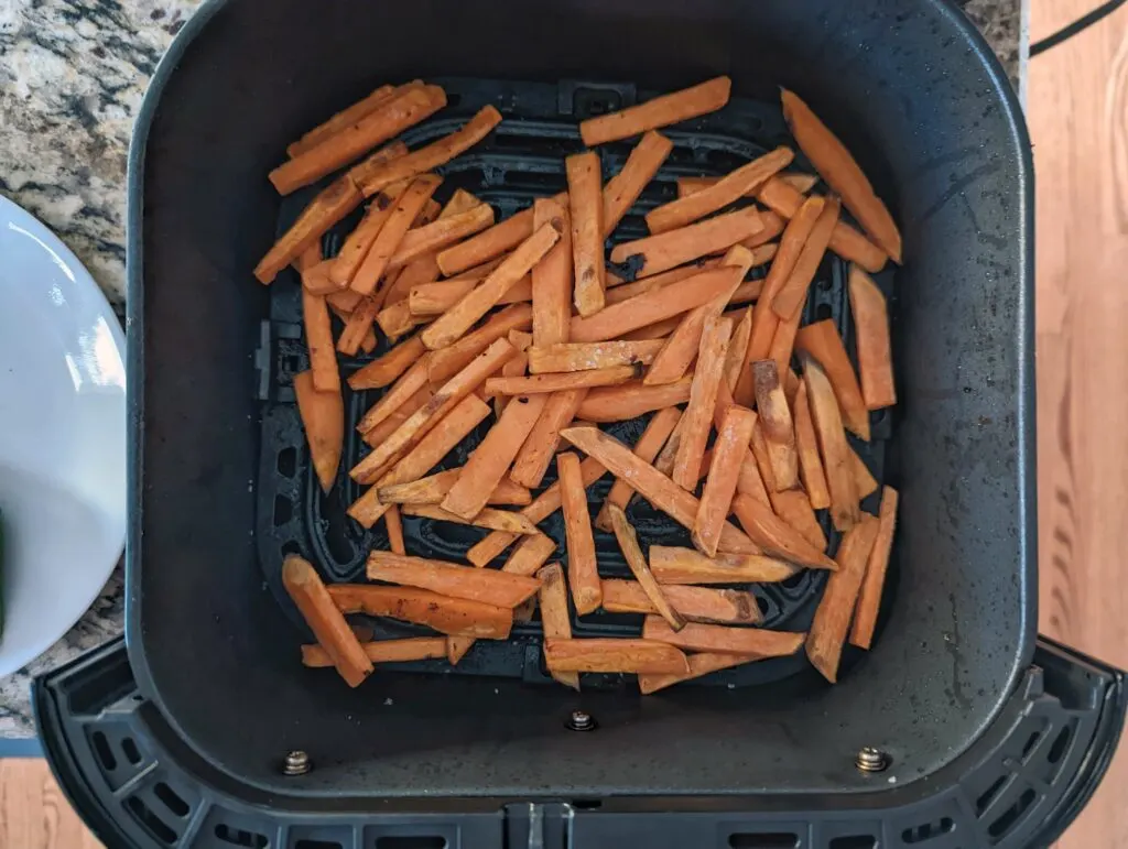 Add the sweet potato fries to the air fryer tray.