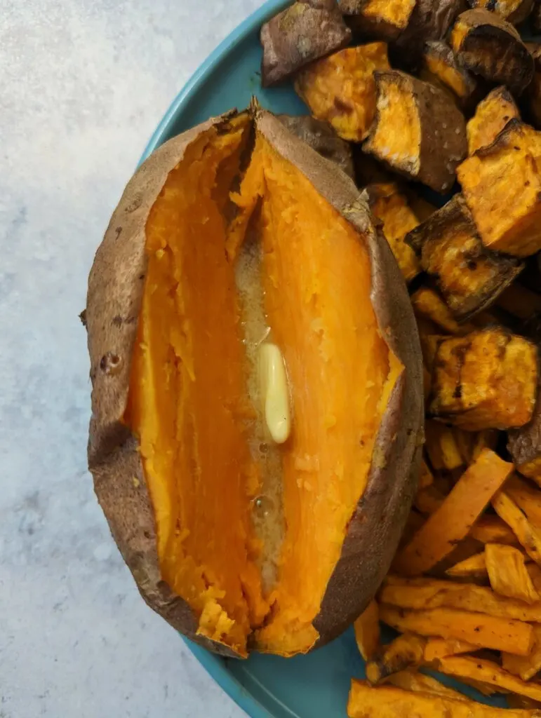 Baked sweet potatoes on a plate and garnished with butter.
