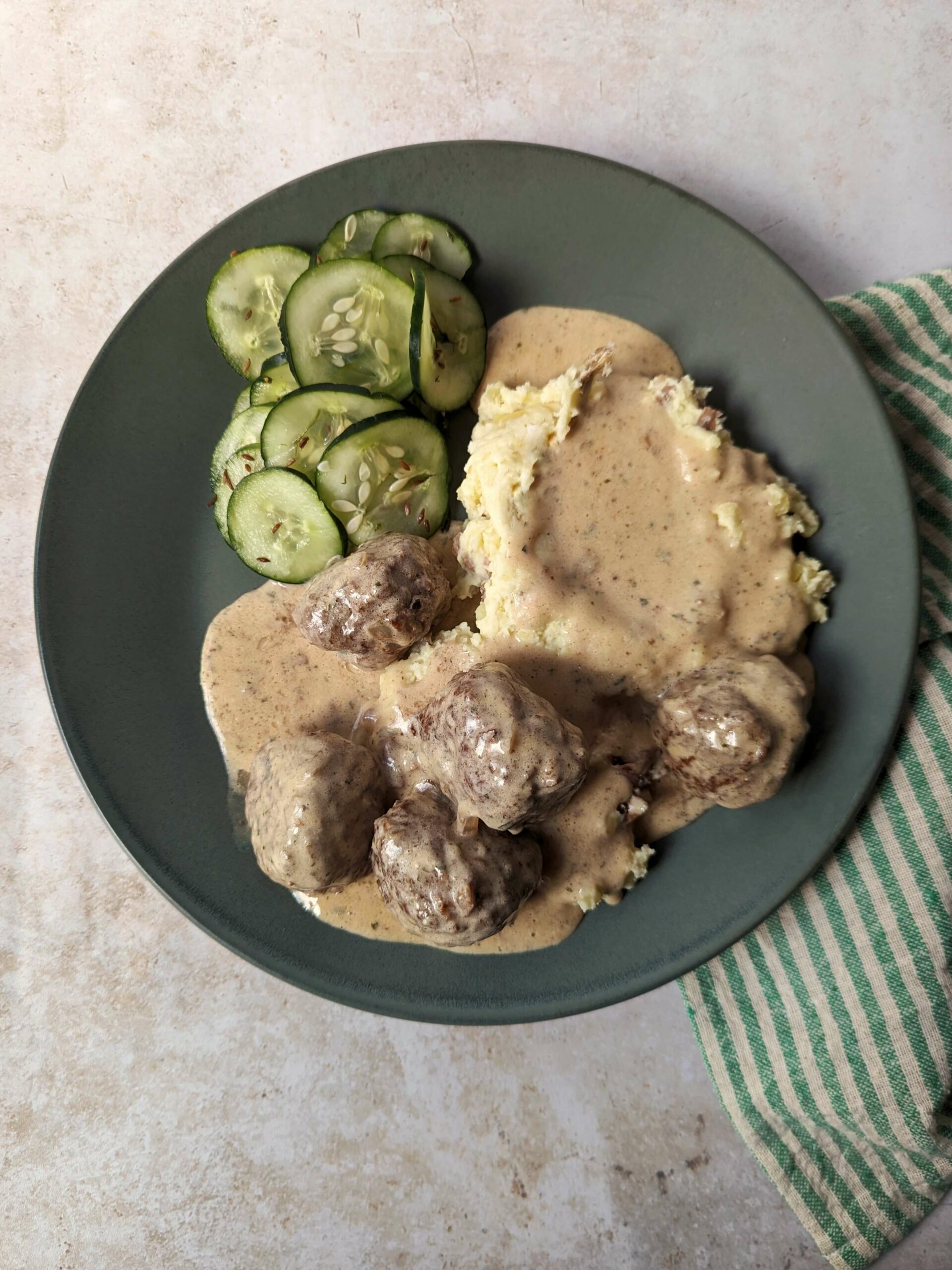 Our IKEA Swedish Meatballs Recipe served with cucumber salad and mashed potatoes.