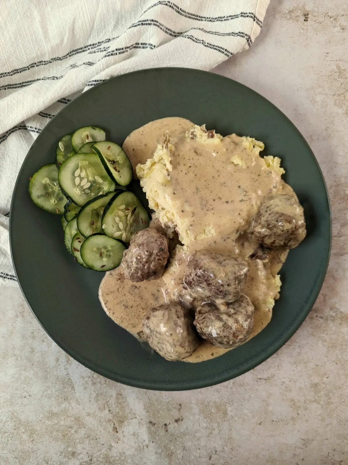 Our IKEA Swedish Meatballs Recipe served with cucumber salad and mashed potatoes.