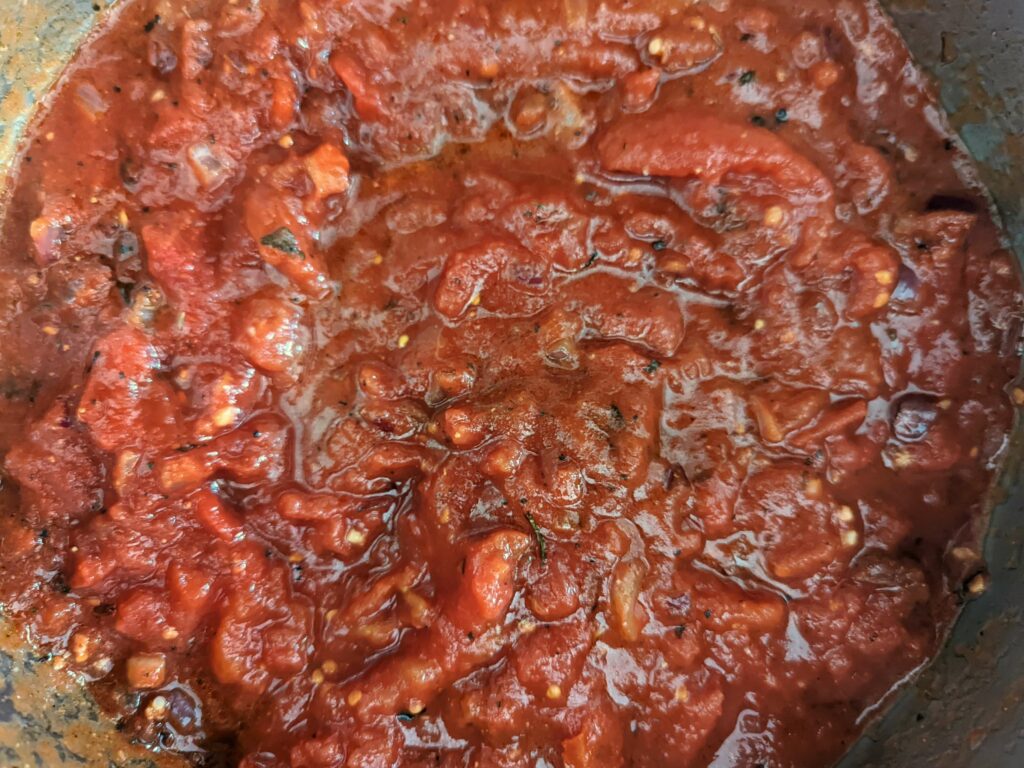 A close up of the cooking spicy marinara sauce.