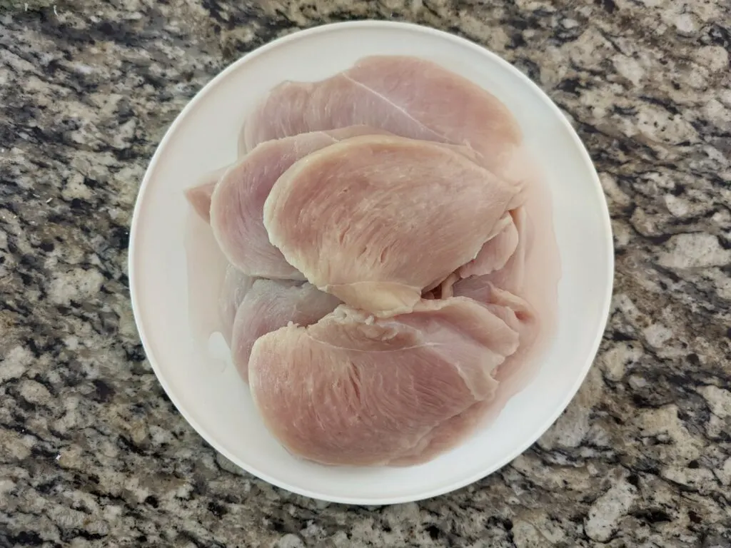 Chicken breasts sliced in half lengthwise.