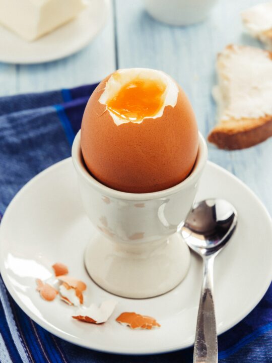A perfectly cooked soft boiled egg cracked open.