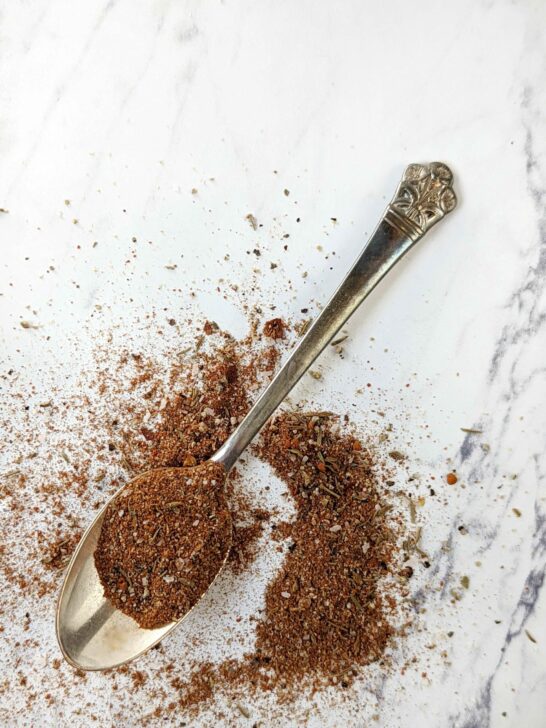 A spoon of Jamaican Jerk Seasoning spilled on the table.