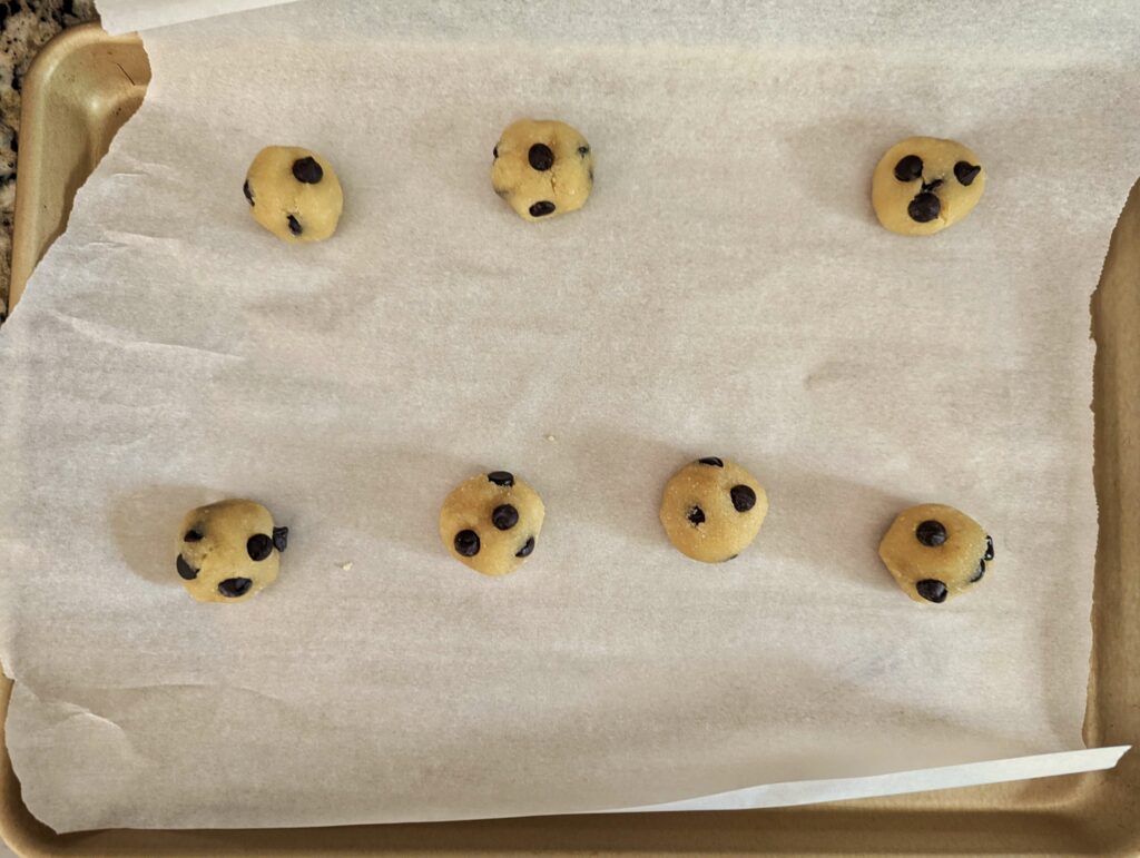 Cookie dough lined on a baking sheet.