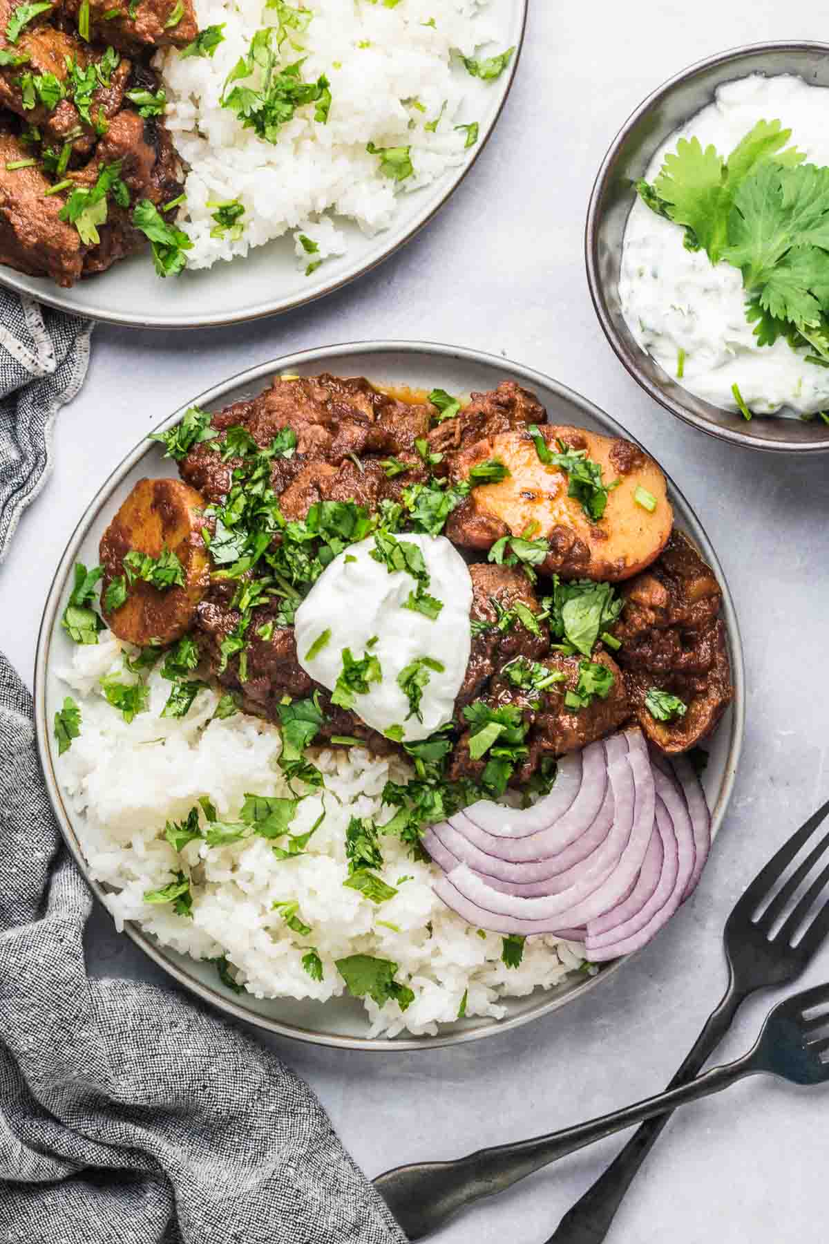 Lamb vindaloo topped with cream, cilantro, and onions.